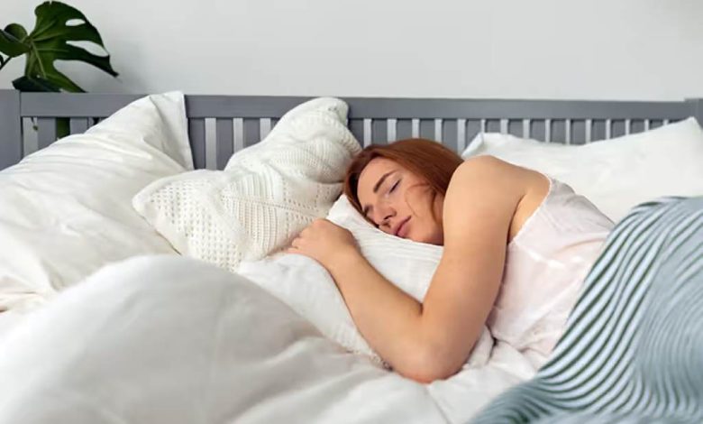 Woman sleeping peacefully on LOFE organic buckwheat pillow with calm expression and open window showing fresh air