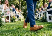 wearing comfortable tan leather loafers with a blue wedding suit walking on grass.