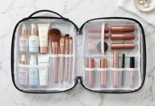 Organized cosmetics inside clear travel makeup bag on marble counter