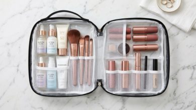 Organized cosmetics inside clear travel makeup bag on marble counter