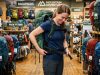 Woman trying on an ergonomic hiking backpack in an outdoor store.