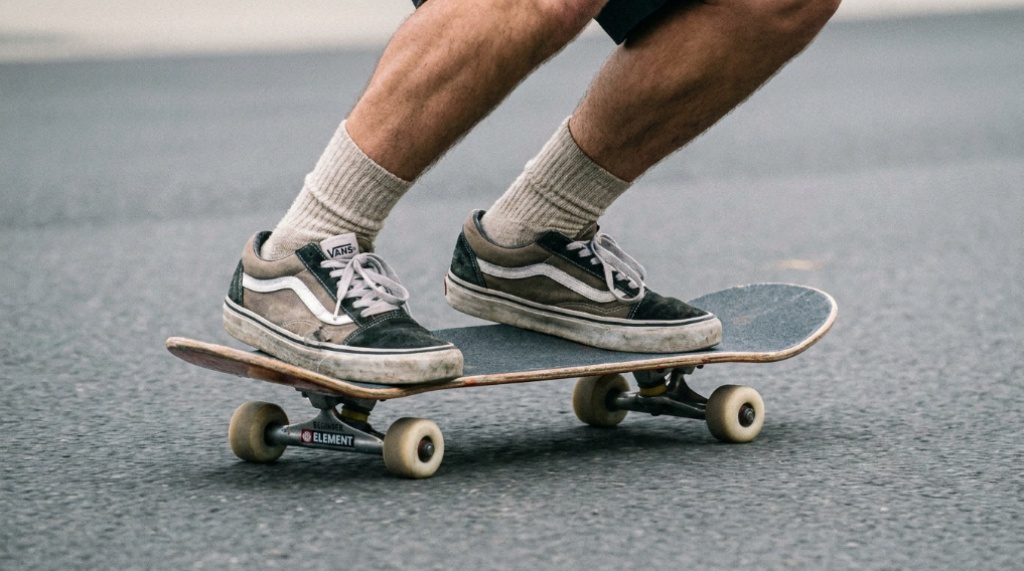 Close-up of adult feet balancing on a skateboard deck.