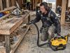 Contractor cleaning construction debris with DEWALT DCV581H vacuum on job site.